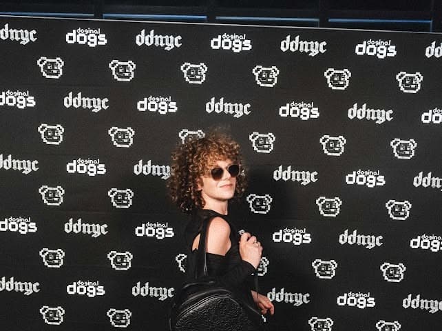 Vee (Vee Meta) at a Doginal Dogs DDNYC event Vee (Vee Meta) in sunglasses at a Doginal Dogs DDNYC step-and-repeat backdrop